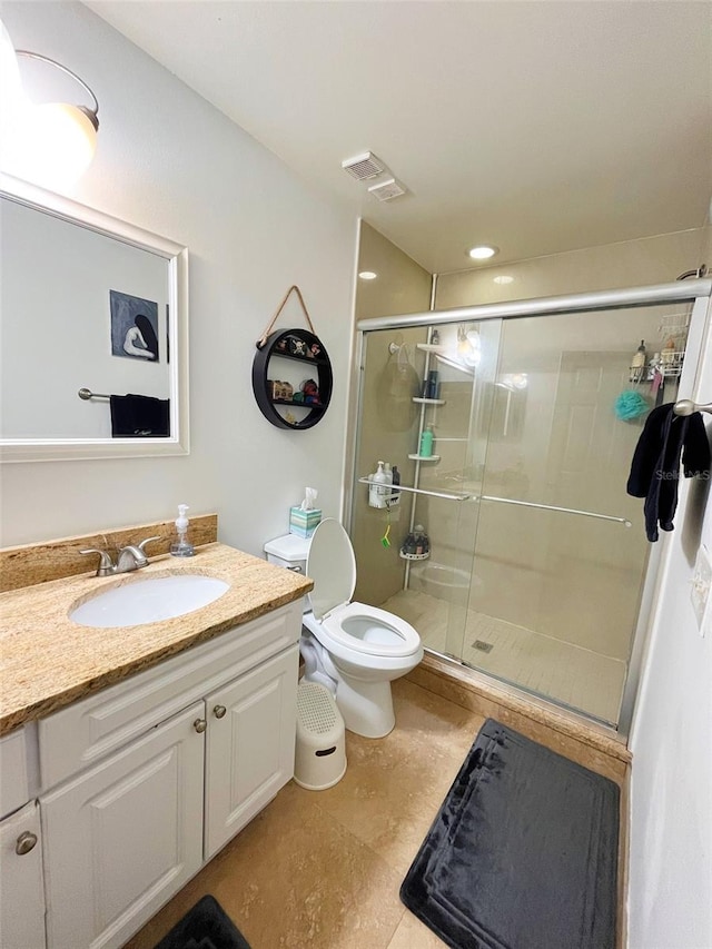 full bathroom featuring toilet, a stall shower, visible vents, and vanity
