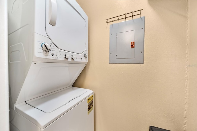 washroom with electric panel and stacked washer and clothes dryer