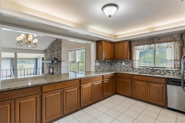 kitchen with a notable chandelier, dishwasher, light stone countertops, and sink