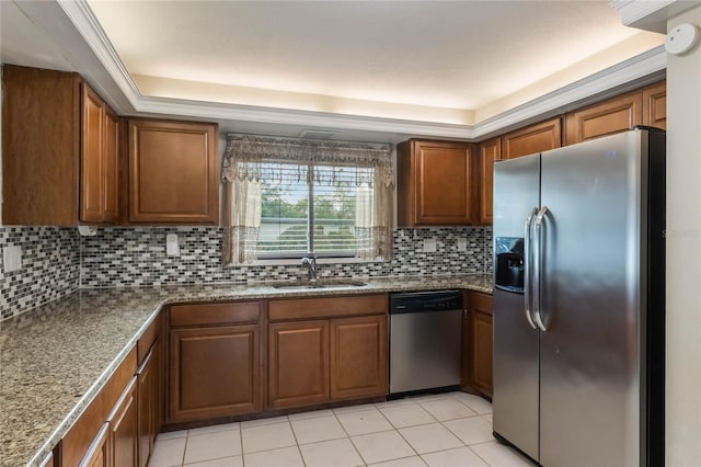 kitchen with backsplash, stainless steel appliances, a tray ceiling, sink, and light tile patterned floors