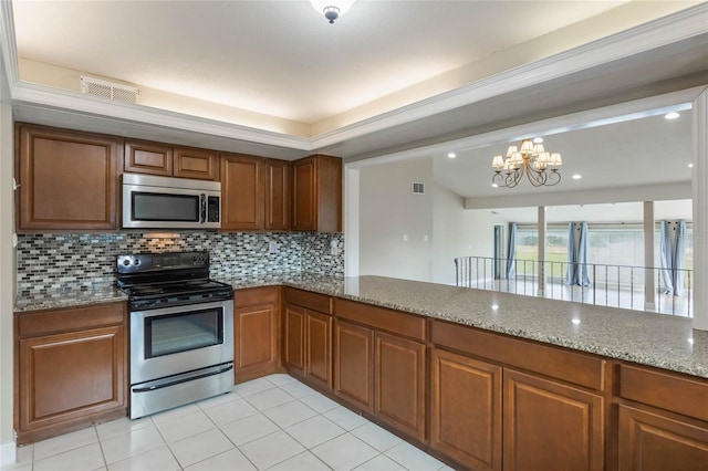 kitchen with decorative backsplash, appliances with stainless steel finishes, light stone counters, light tile patterned floors, and an inviting chandelier