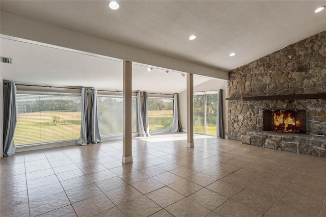 unfurnished living room featuring track lighting, a fireplace, and vaulted ceiling