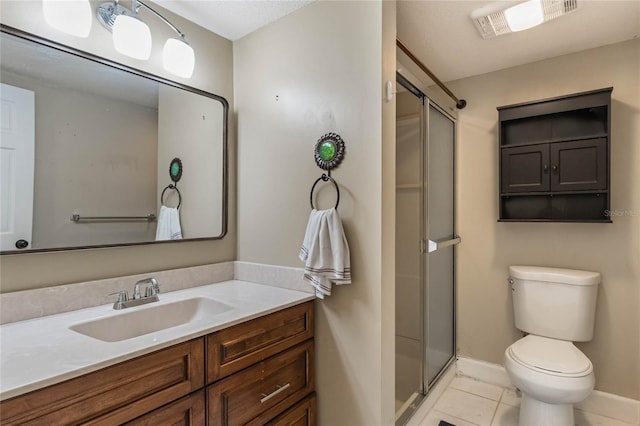 bathroom featuring tile patterned floors, a shower with door, vanity, and toilet