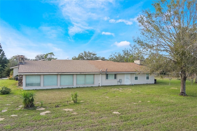 rear view of property with a lawn