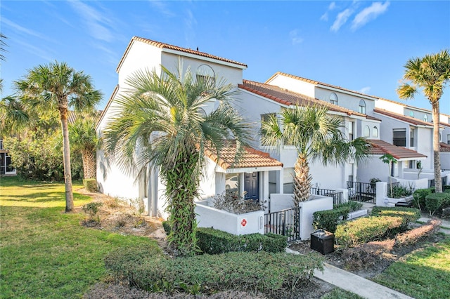 mediterranean / spanish home with a front lawn