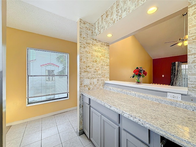 kitchen featuring ceiling fan, gray cabinets, light tile patterned floors, and a textured ceiling