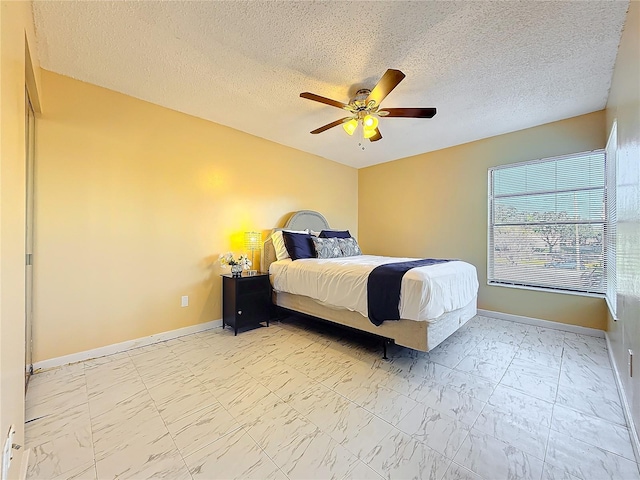 bedroom with ceiling fan and a textured ceiling