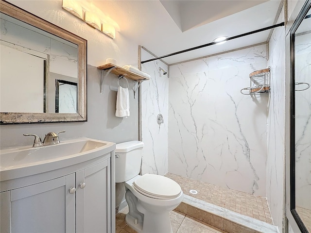 bathroom featuring a tile shower, vanity, and toilet