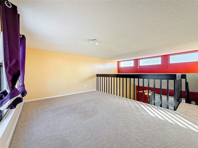 carpeted spare room with a textured ceiling