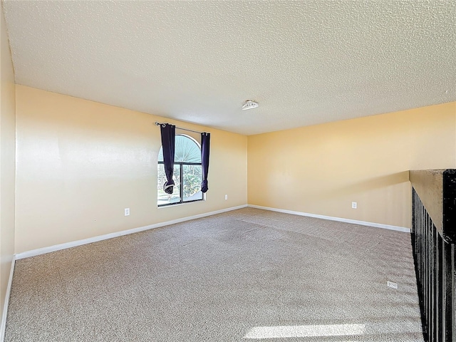 carpeted empty room featuring a textured ceiling