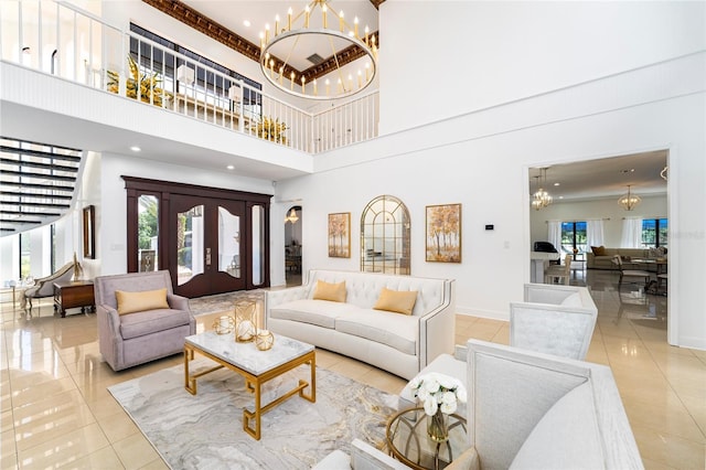 living room with a notable chandelier, light tile patterned flooring, a towering ceiling, and a healthy amount of sunlight