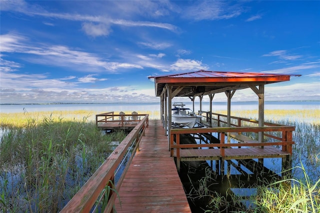 view of dock with a water view and a view of the beach