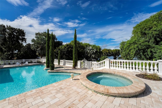 view of pool featuring a patio area and an in ground hot tub