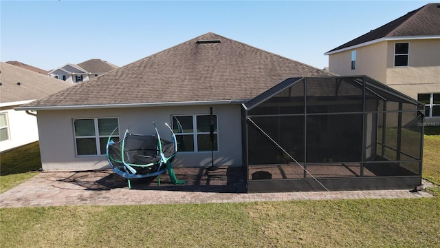 back of house featuring a lawn, a patio area, and a lanai