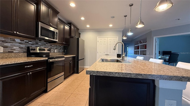 kitchen with sink, a center island with sink, decorative light fixtures, and appliances with stainless steel finishes