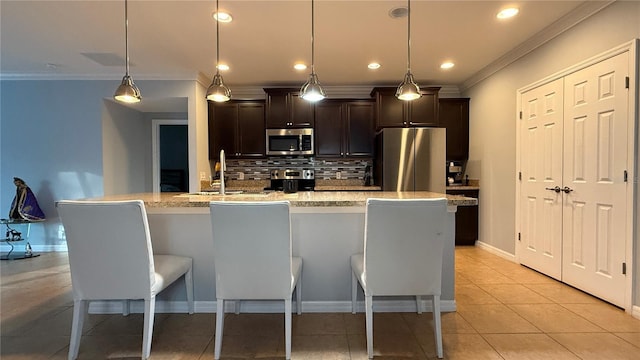 kitchen with sink, stainless steel appliances, decorative light fixtures, a center island with sink, and light tile patterned floors