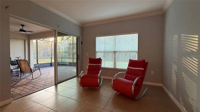 living area with tile patterned floors, ceiling fan, and ornamental molding