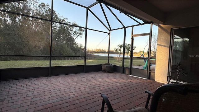 patio terrace at dusk with a lanai and a water view