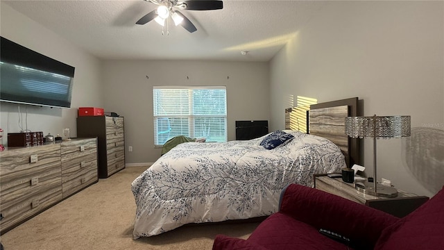 carpeted bedroom featuring ceiling fan and a textured ceiling