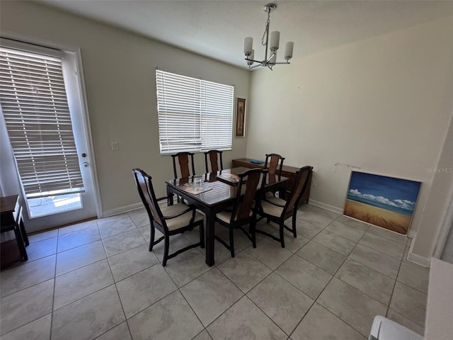 tiled dining area featuring an inviting chandelier