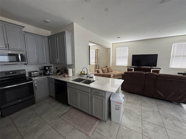 kitchen featuring black appliances, kitchen peninsula, sink, and gray cabinets