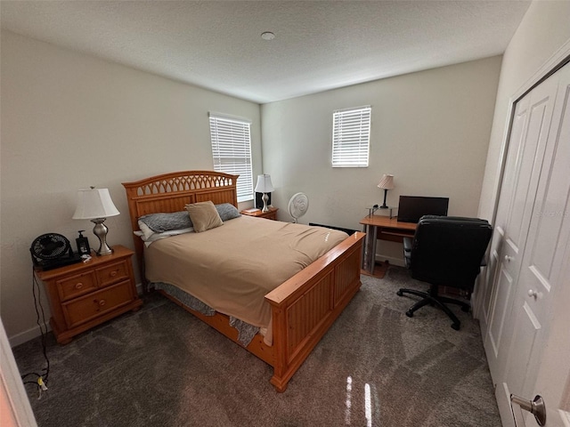 bedroom featuring dark carpet, a closet, and a textured ceiling