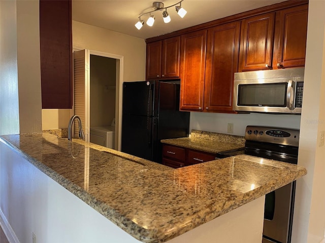 kitchen featuring kitchen peninsula, appliances with stainless steel finishes, light stone counters, and sink