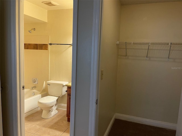 bathroom featuring tile patterned flooring, shower / bath combination, and toilet