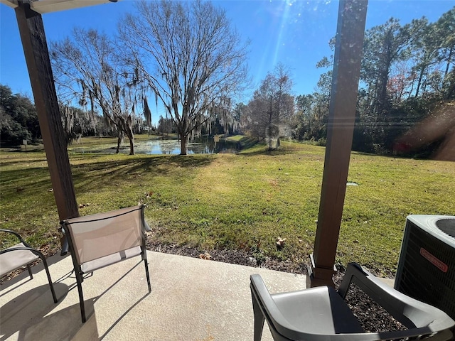 view of yard with a patio, a water view, and central AC