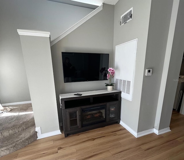 living room with light wood-type flooring and ornamental molding