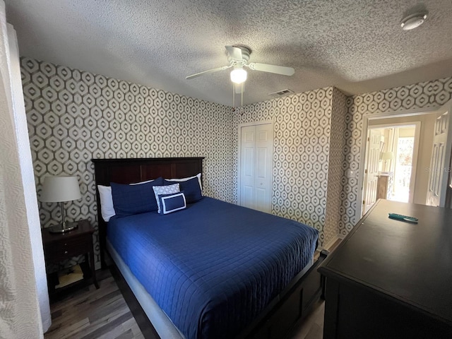 bedroom featuring hardwood / wood-style floors, a textured ceiling, and ceiling fan