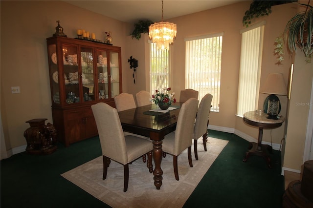 dining room with carpet floors and a notable chandelier