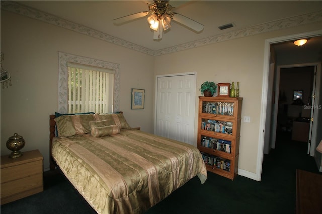 carpeted bedroom with ceiling fan and a closet