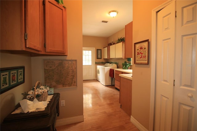 hallway with light hardwood / wood-style floors and washer and clothes dryer