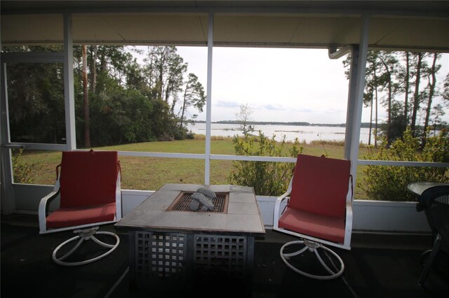 sunroom featuring a water view