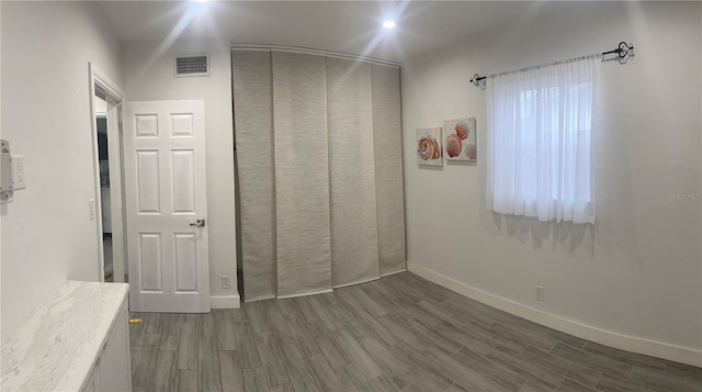 unfurnished bedroom featuring a closet and wood-type flooring