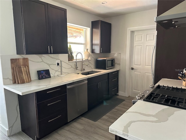 kitchen featuring sink, stainless steel appliances, island exhaust hood, and light stone countertops