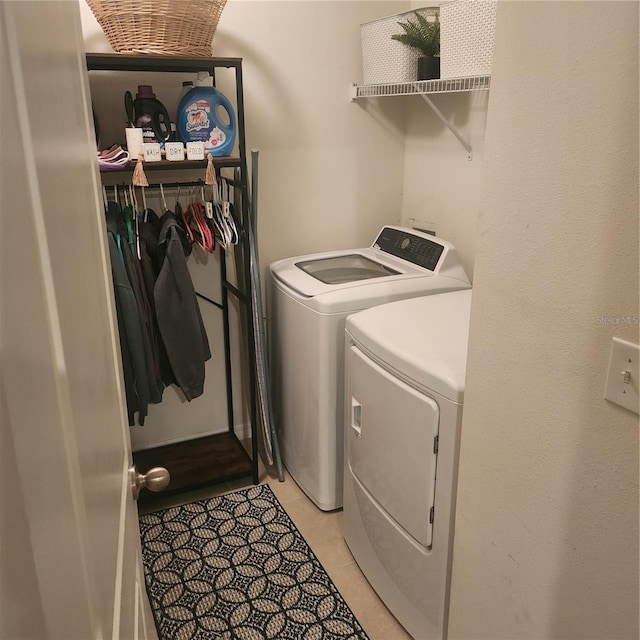 clothes washing area featuring washing machine and clothes dryer and light tile patterned floors