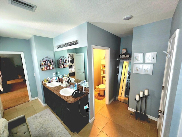 bathroom featuring tile patterned flooring, a sink, and baseboards