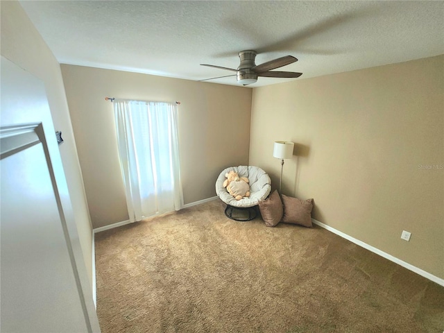 unfurnished room with carpet, a ceiling fan, a textured ceiling, and baseboards