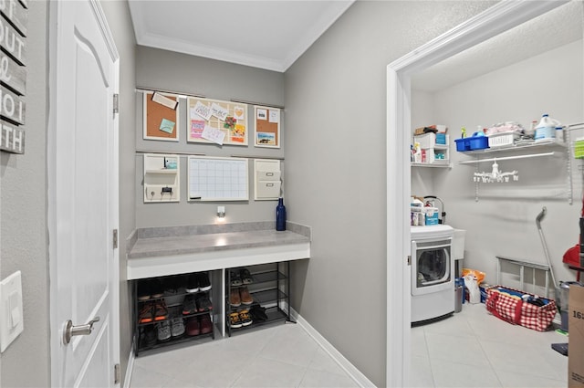 clothes washing area featuring light tile patterned floors, crown molding, and washer / clothes dryer