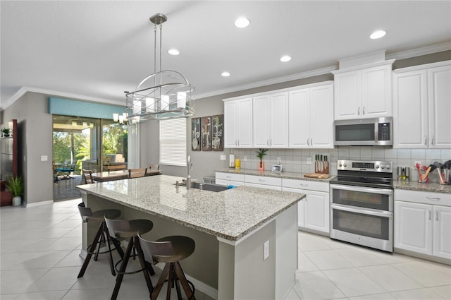 kitchen featuring white cabinets, appliances with stainless steel finishes, and a kitchen island with sink