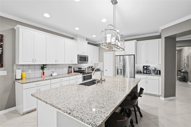 kitchen featuring white cabinets, a kitchen island with sink, appliances with stainless steel finishes, and sink