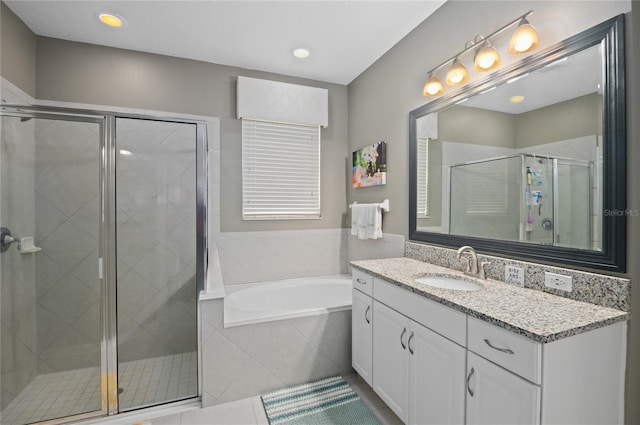 bathroom with tile patterned flooring, vanity, and shower with separate bathtub