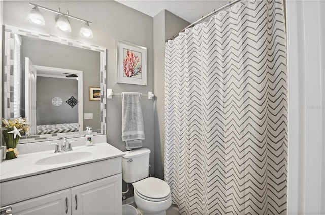 bathroom with toilet, vanity, and curtained shower