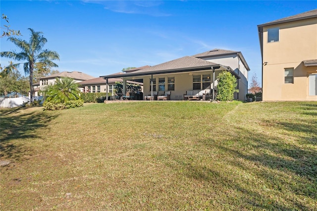 rear view of house featuring a patio and a yard