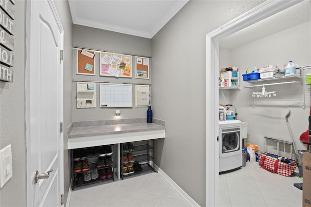 clothes washing area featuring washer / dryer, crown molding, tile patterned floors, and baseboards