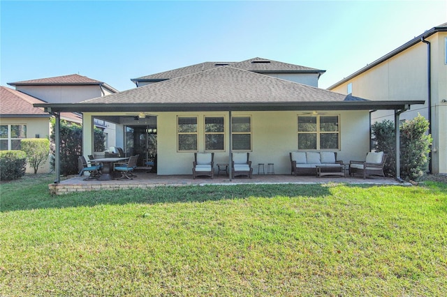 back of property with ceiling fan, outdoor lounge area, a patio area, and a lawn