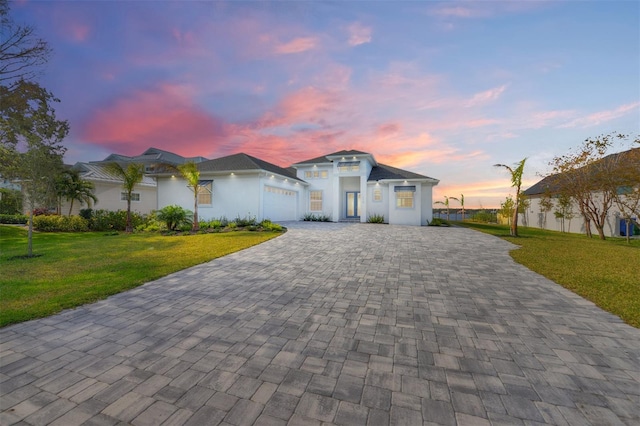 view of front of house featuring a garage and a lawn