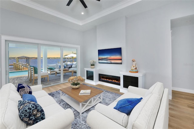 living room featuring ceiling fan, light hardwood / wood-style flooring, and crown molding